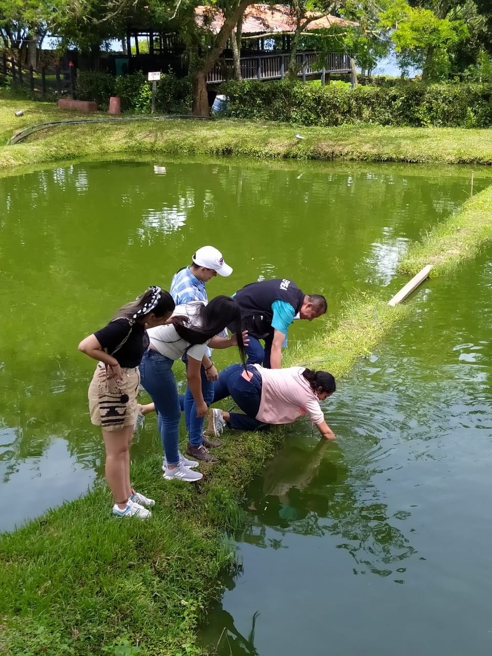 Estudiantes de noveno demostrando la forma en que se puede medir turbidez manualmente en los estanques de tierra de Hacienda Majavita